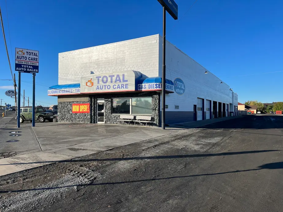 The Total Auto Care building from the lot, bay doors running down the side