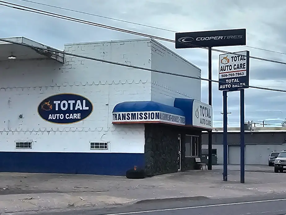 The Total Auto Care oval on the white cinderblock wall, the transmission awning and the Cooper Tires pole sign