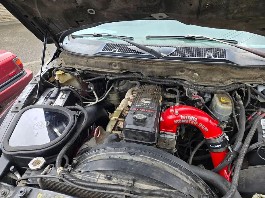 Cummins 24V turbo diesel under an open hood, red Banks intake elbow fitted