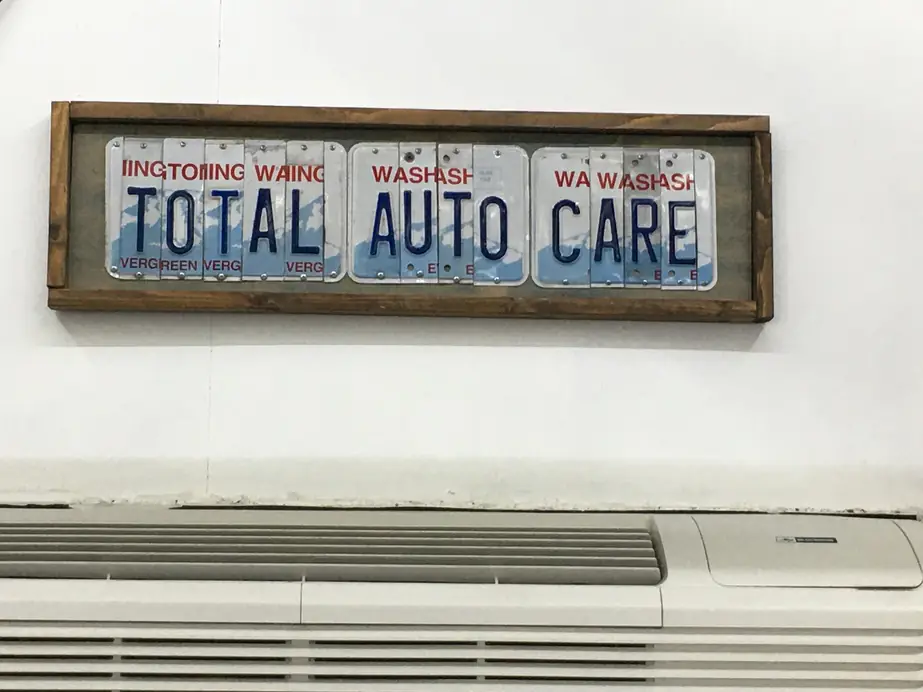 TOTAL AUTO CARE spelled in cut Washington licence plates, framed in wood on the shop wall